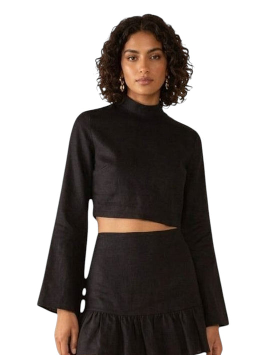 Paula Fashion House black linen mock-neck crop top with bell sleeves and button cuffs, paired with a ruffled skirt.
