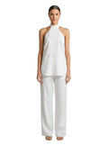 Paula Fashion House white wide-leg linen trousers with a high waist and relaxed fit. Model wearing the trousers with a matching halter top.